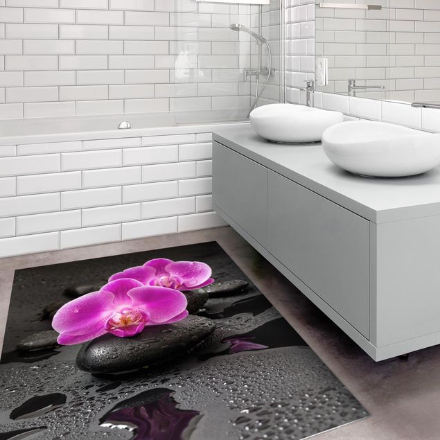 Tappeti moderni soggiorno Fiore di orchidea rosa su pietra con gocce