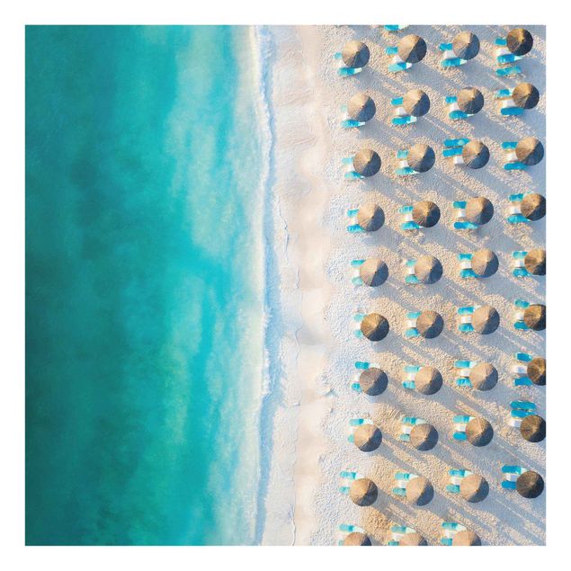 Quadro in vetro - Spiaggia sabbiosa bianca con ombrelloni di paglia