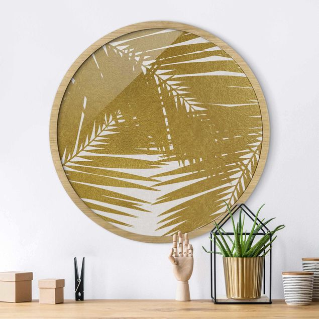 Poster con cornice rotonda Vista attraverso le foglie di palma dorate